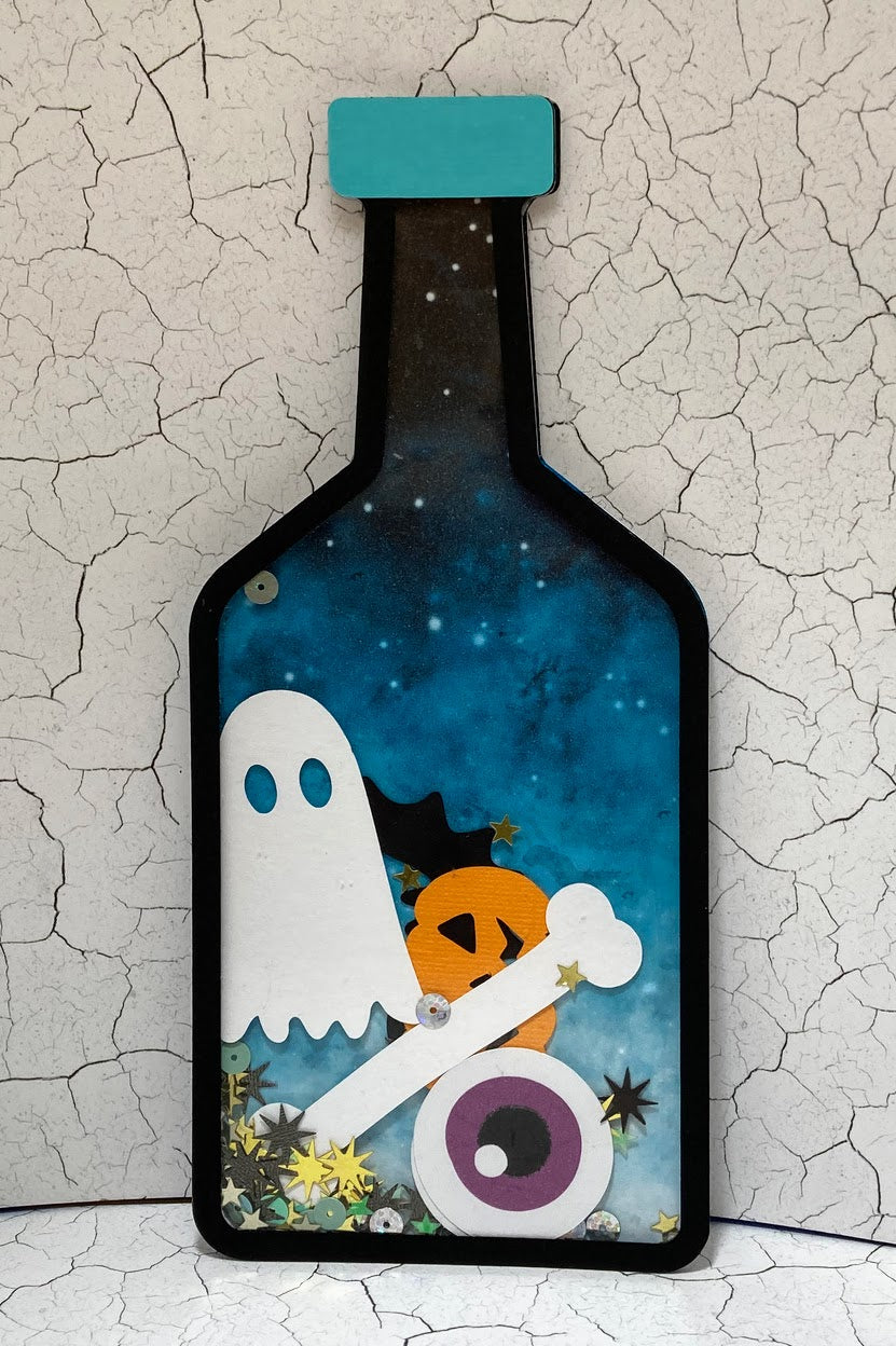 Blue long-necked potion bottle shaker with a ghost, pumpkin, bone and sequins.