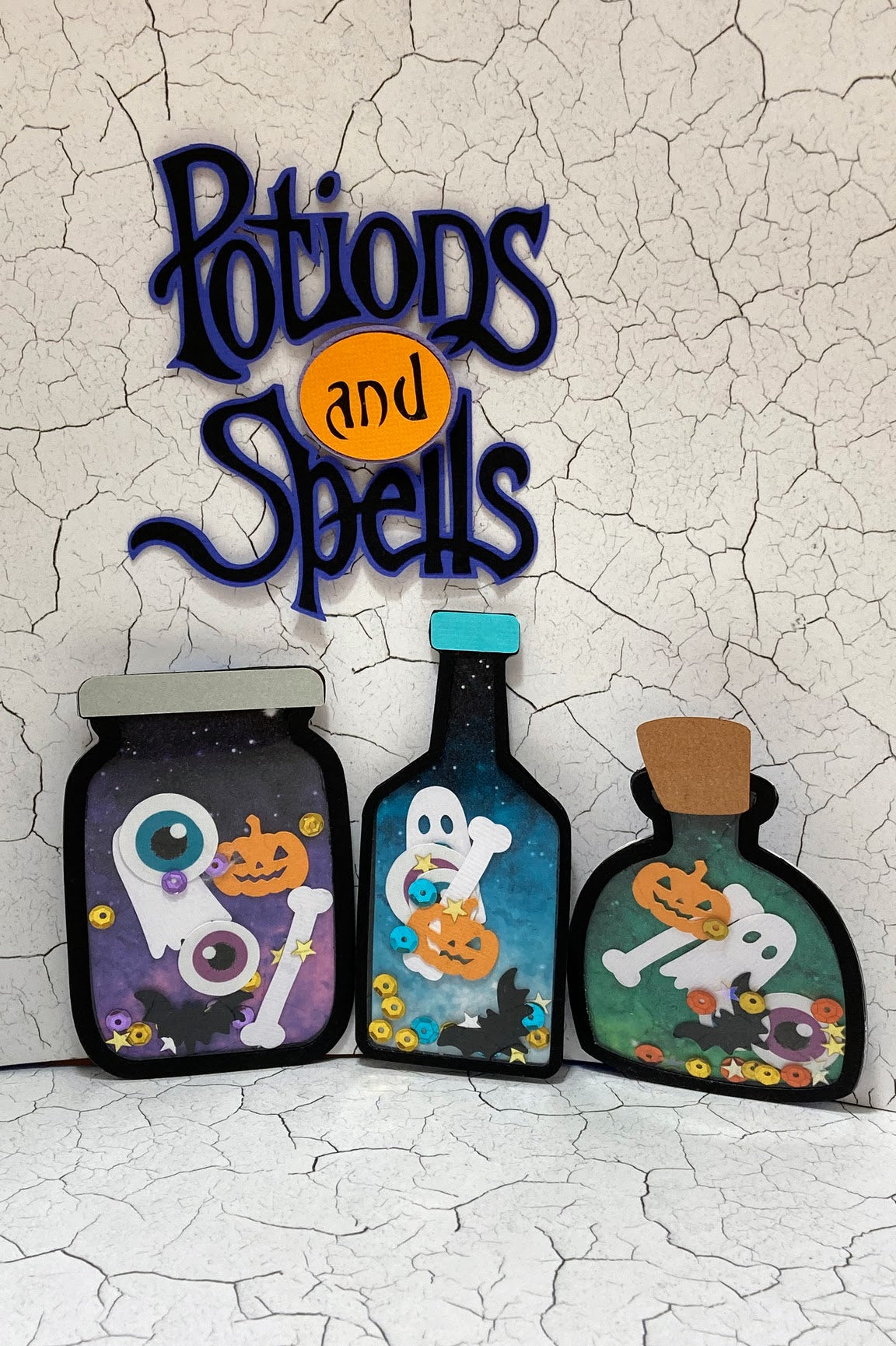 Halloween set of three potion bottle shakers with a matching Potions and Spells decorative title.